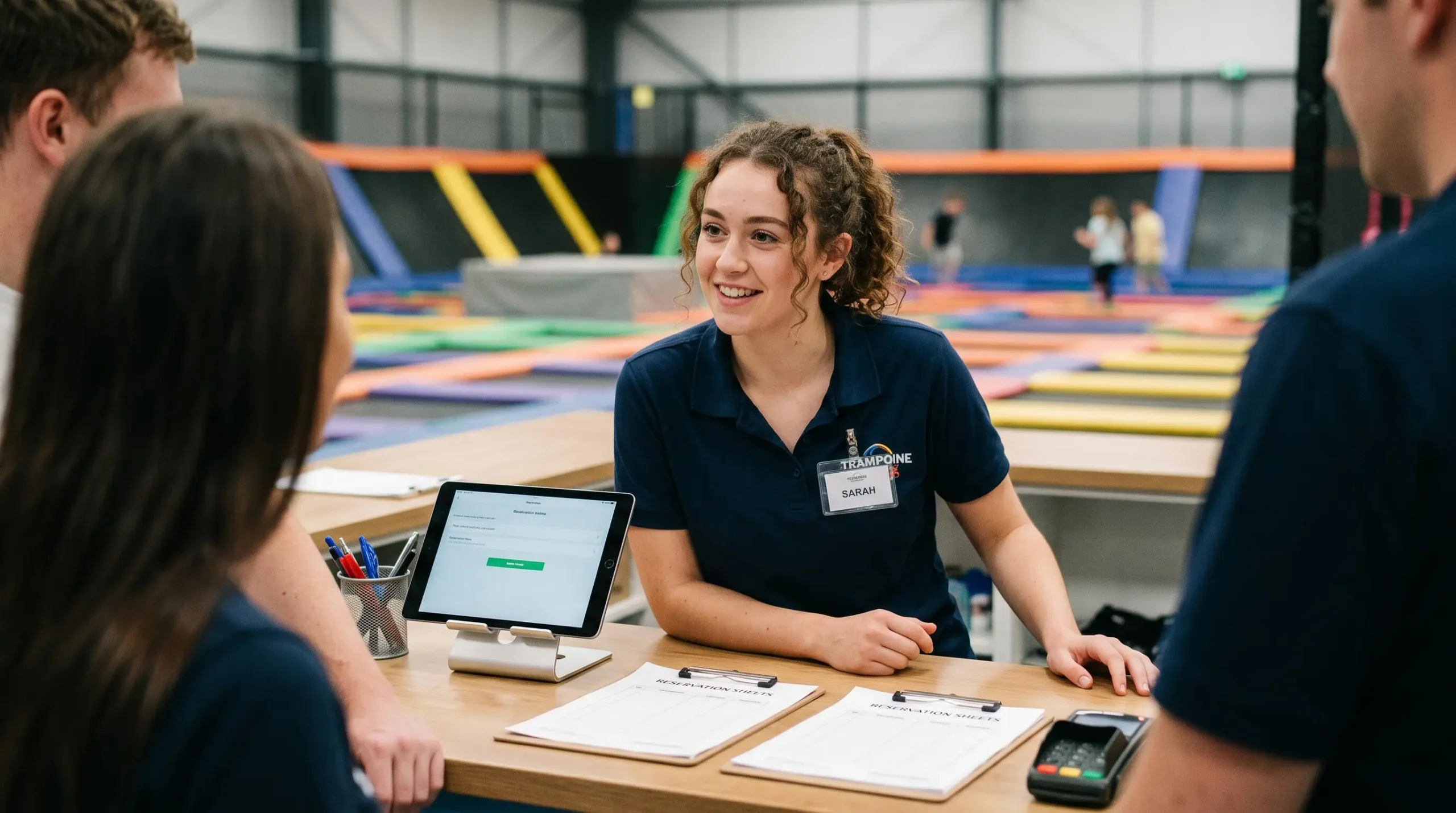 Un employé accueille des visiteurs à la réception du trampoline park.